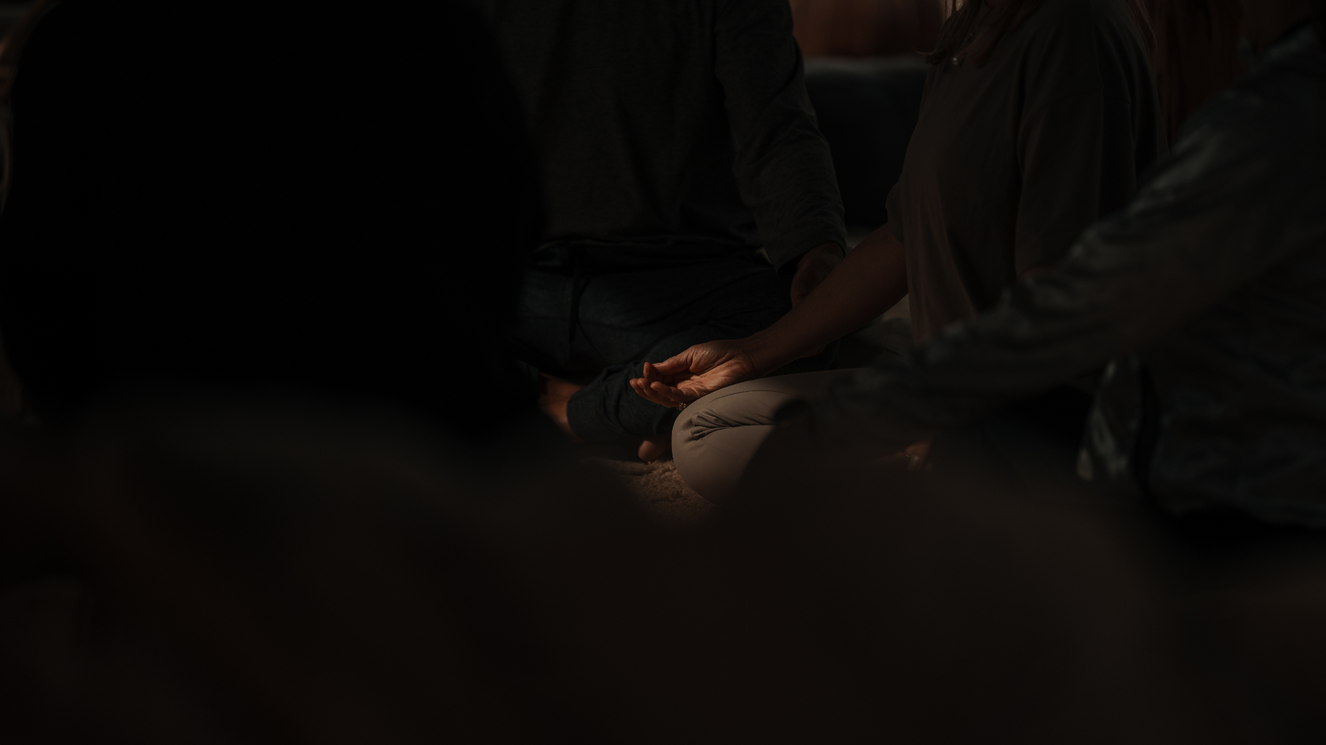 Group meditation practice, hands resting in stillness