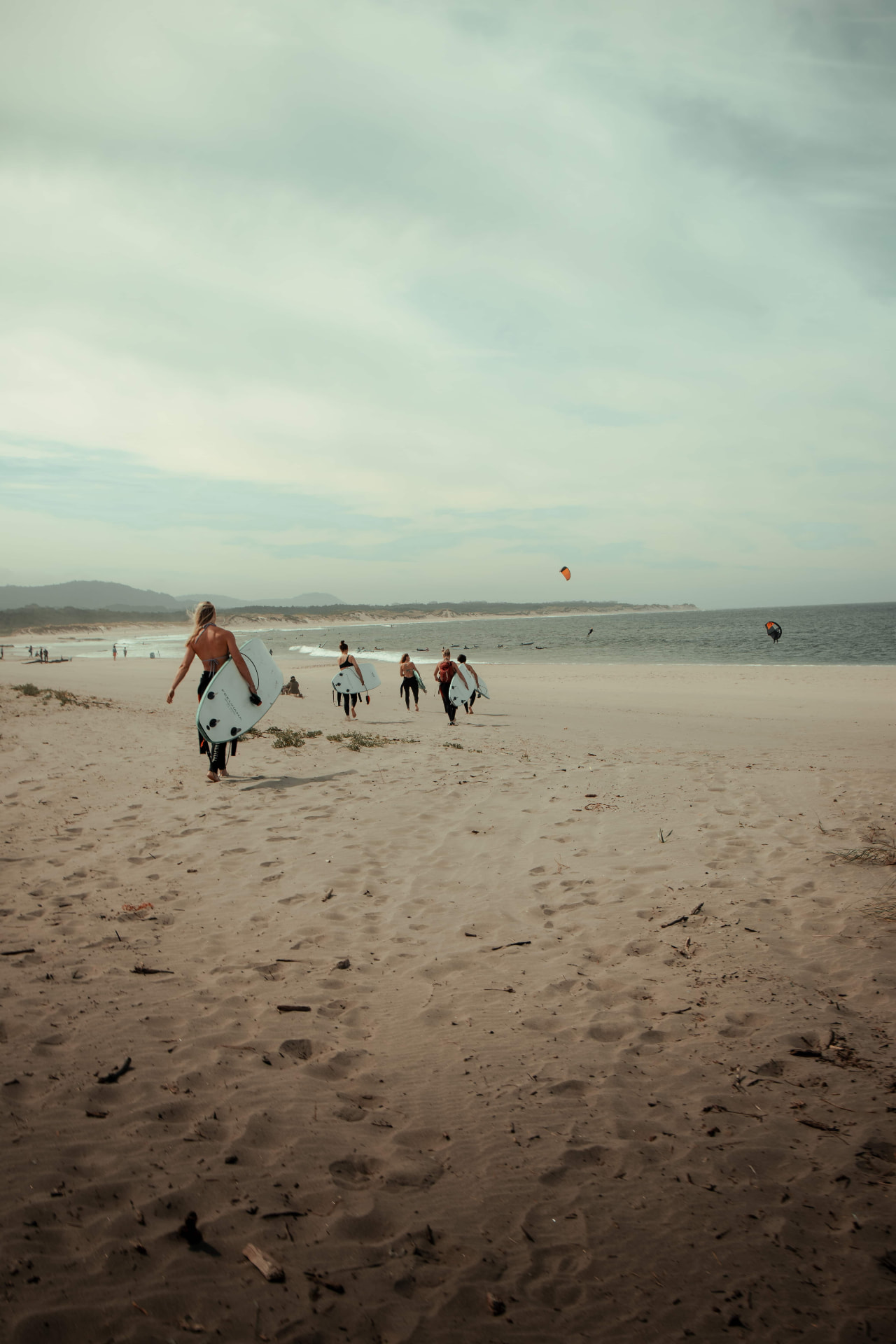 Guests walking to the ocean with surfboards at a Kaer retreat