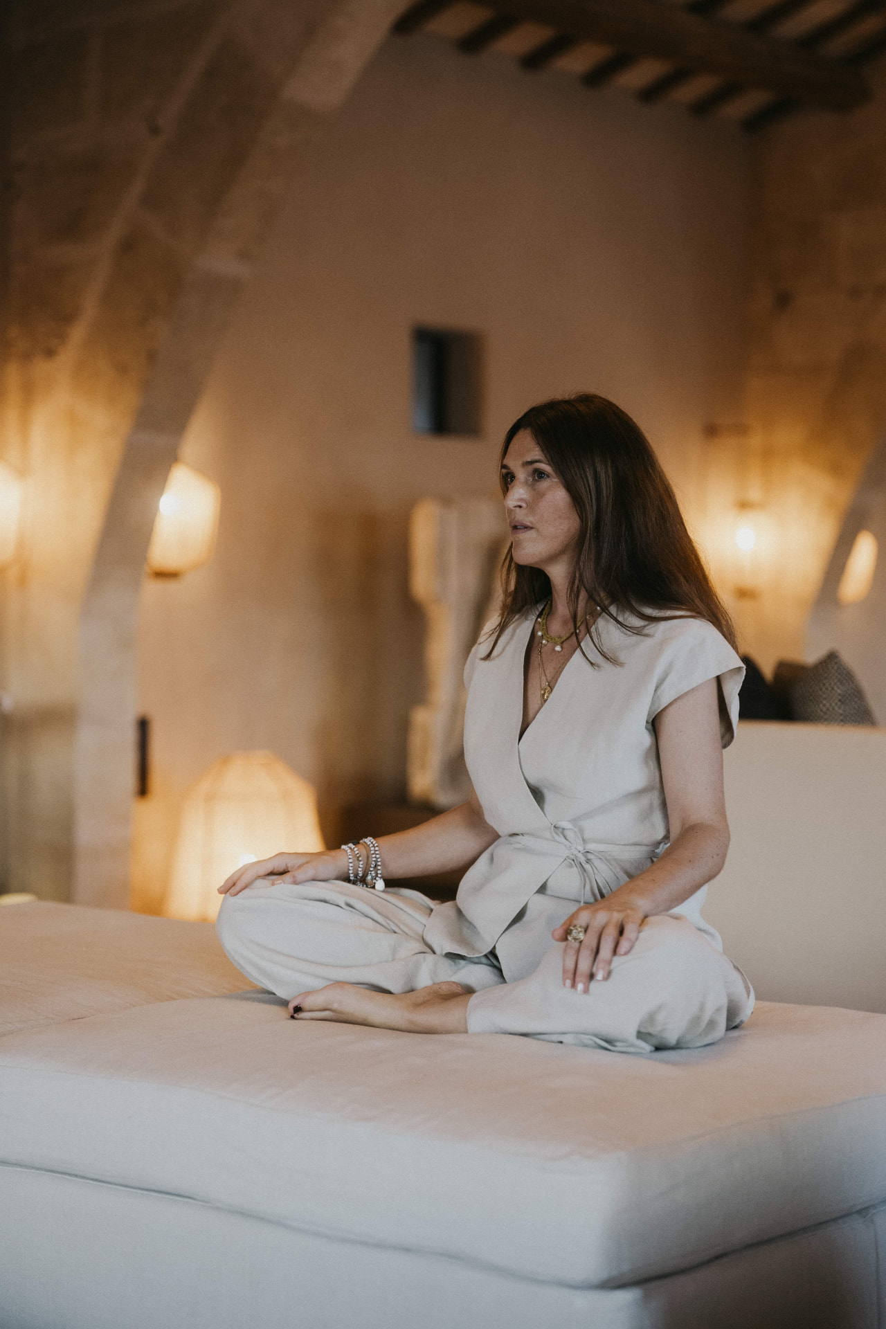 A facilitator seated in a warm lamplit room at a Kaer retreat